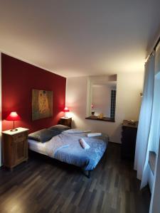 1 dormitorio con 2 camas y pared roja en Apartments Volče, en Tolmin