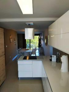 una cocina con una isla blanca en una habitación en Appartement Rêve-Catalan 2 chambres en Perpiñán