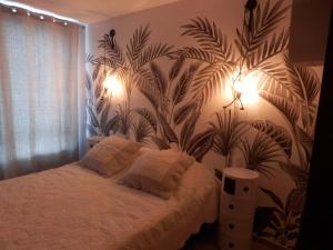 1 dormitorio con 1 cama con un mural de plantas en la pared en Appartement Rêve-Catalan 2 chambres en Perpiñán