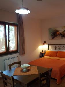 a bedroom with a bed and a table and a dining room at Poggiofelice B&B in Zafferana Etnea