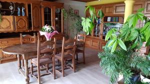 ein Esszimmer mit einem Tisch und einigen Pflanzen in der Unterkunft Les Glycines in Gouvy