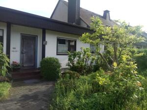 una casa blanca con una puerta y algunos arbustos en WenneGlück, en Meschede