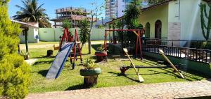 a playground with a slide and a swing set at Duas Praias Hotel Pousada in Guarapari