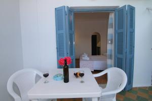 a white table with two glasses and a bottle of wine at Sea Breeze in Paleokastritsa +31 photos