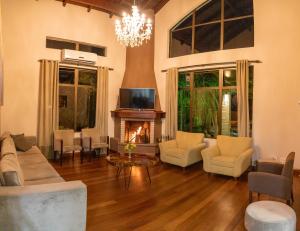 a living room with a fireplace and a couch and chairs at Hotel Pousada Kaster in Gramado