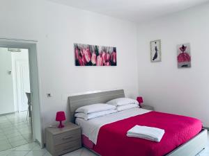 um quarto branco com uma cama com um cobertor vermelho em Casa Sofia em Sorrento
