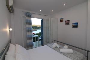 a bedroom with a bed and a balcony at Sea Breeze in Paleokastritsa