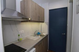 a kitchen with a sink and a blue door at Sea Breeze in Paleokastritsa