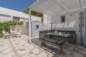 a patio with a table and chairs and a pergola at Aretis home in Plaka Milou