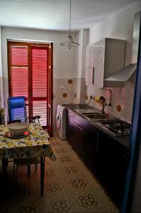 - une cuisine avec une table, une cuisinière et un évier dans l'établissement Tra mare e collina c'è Belmare, à Montecorice