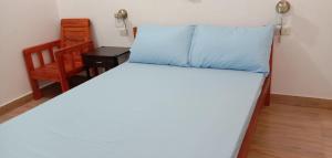 1 dormitorio con 1 cama y 1 silla en Pentaqua -Dineros Guest House, en Irosin