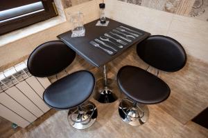 a black table with two chairs and a table with wine glasses at Sud Dreams Apartments in Bucharest