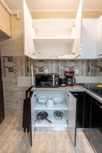 a kitchen with white cabinets and a microwave at Sud Dreams Apartments in Bucharest
