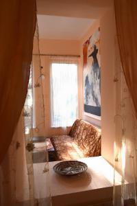 uma pequena sala de estar com um sofá e uma janela em Stone Garden em Liepāja