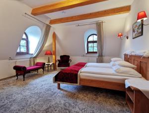 a bedroom with a large bed and two windows at Dworek Kazimierski in Kazimierz Dolny