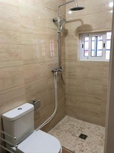 a bathroom with a shower with a toilet and a shower head at Lisbon South Bay Rooms in Amora
