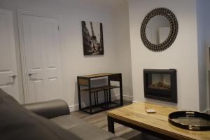 a living room with a couch and a table and a mirror at Palm House in Widnes