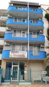 a blue building with a sign in front of it at Ivanovi Guest House in Primorsko