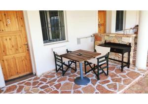 una mesa y un piano sentados junto a una puerta en John's Guesthouse, en Ksamil