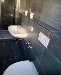 Hotel Unter den Linden في Kierspe: حمام به مرحاض أبيض ومغسلة