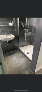 a bathroom with a shower and a sink and a toilet at Hotel Unter den Linden in Kierspe