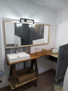 La salle de bains est pourvue d'un lavabo et d'un miroir. dans l'établissement Maison dans quartier calme, à LʼIsle-sur-la-Sorgue