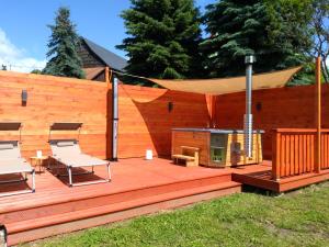 a wooden deck with a grill and a tent at Apartmány Brychovi in Červený Potok