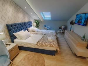 1 dormitorio con 1 cama grande y cabecero azul en Vazdušna Banja, en Niš