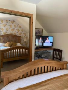 1 dormitorio con cama, espejo y TV en Shenavallie Farm en Benderloch