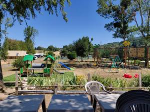 un parque con parque infantil con mesas y sillas en Camping " Le grun de Chignore", en Vollore-Ville