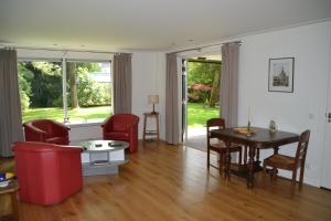 sala de estar con sillas rojas y mesa en Fiddler's Hoorn en Zwaag