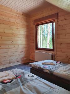 una stanza con due letti in una baita di tronchi di Splife semi-detached cottage a Kuru