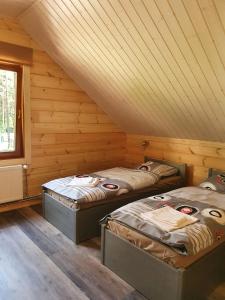 two beds in a room with wooden walls at Splife semi-detached cottage in Kuru