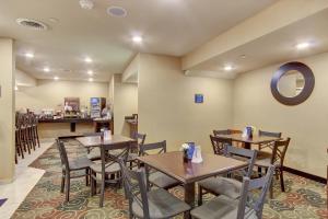 RouzervilleにあるCobblestone Hotel & Suites - Waynesboroのテーブルと椅子、カウンター付きのレストラン