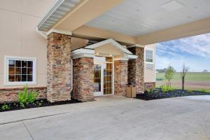a house with a stone wall at Cobblestone Hotel & Suites - Waynesboro in Rouzerville