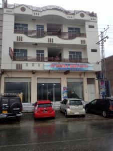 a group of cars parked in front of a building at FR Darya E Swat Hotel in Mingāora