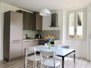 cocina con mesa blanca y sillas blancas en Le Campane Studio Apartment, en Bellagio