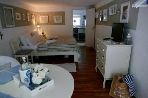 ein kleines Zimmer mit einem Bett und einem Tisch mit Blumen in der Unterkunft Kleine Ferienwohnungen - Störtebeker in Ralswiek