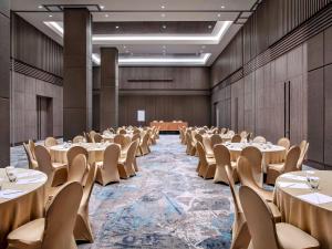 una grande sala banchetti con tavoli e sedie di Mercure Tangerang BSD City a Tangerang Altre 37 foto