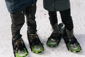 dos personas están de pie en los esquís en la nieve en LakeLodge Kiehinen & Igloos en Rovaniemi