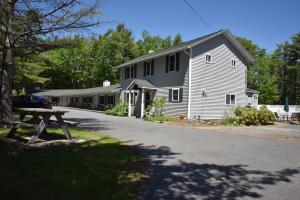 een wit huis met een picknicktafel ervoor bij Acadia Pines Motel in Bar Harbor