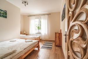 Schlafzimmer mit einem Bett und einem Fenster in der Unterkunft Domki pod Strzechą in Zakopane