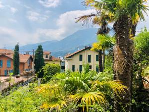 un pueblo con palmeras y montañas en el fondo en Le Campane Studio Apartment, en Bellagio