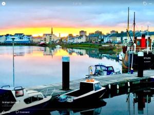 a group of boats docked at a marina at sunset at Harbourlights Accomodation in Irvine