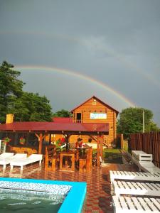 einen Regenbogen am Himmel über einem Haus mit Pool in der Unterkunft Fiesta in Solotwyno