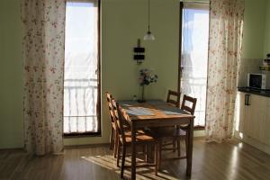 a dining room table and chairs in a kitchen with windows at Apartament Motyl in Władysławowo