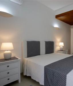 een slaapkamer met een wit bed en 2 lampen bij Cala Azul Residence B&B in Alghero