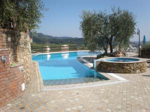 una gran piscina con una pared de ladrillo en Villa La Pianella, en Massarosa