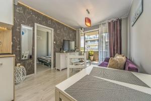a room with a bed and a living room at Apartament LUX in Pruszcz Gdański