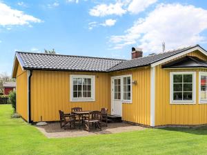 a yellow house with a table and chairs at Two-Bedroom Holiday home in Tvååker in Tvååker